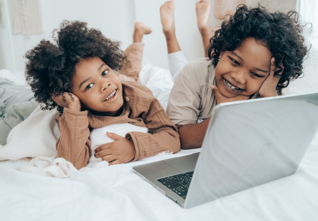 Two small girls on bed with laptop